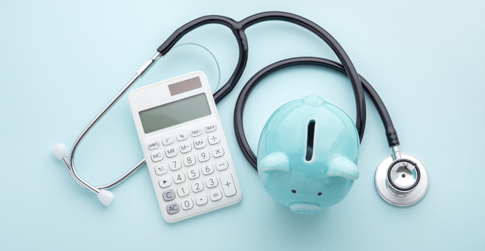 blue piggy bank, calculator, stethoscope 
