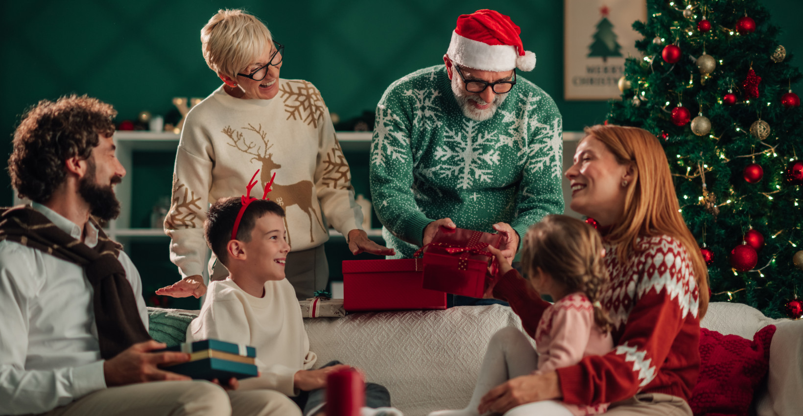 a family laughs together opening christmas presents