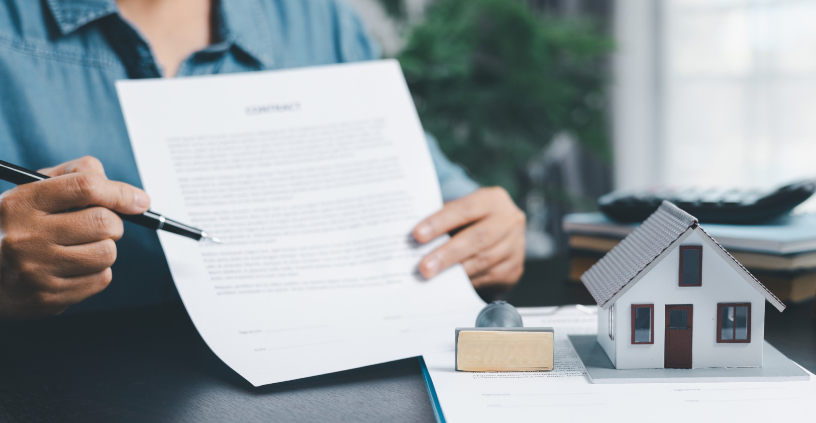 a person holds up a piece of paper and points to it with a pen