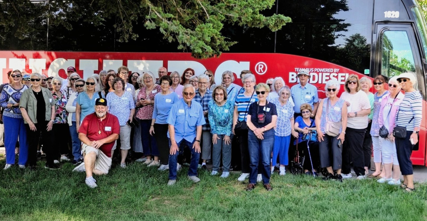 a group of UBT Journey program participants stand in front of a bus