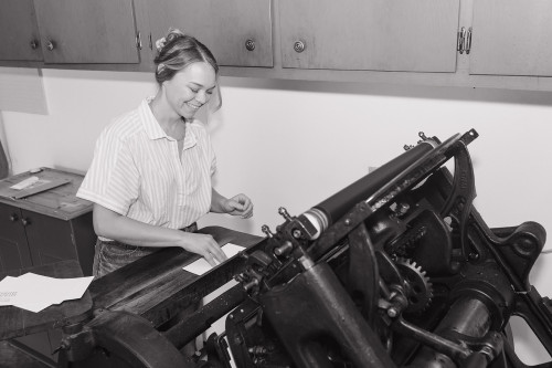 Lindsay Griepenstroh stands at her vintage letter press machine