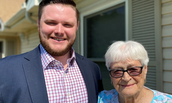 A handsome young man posing with an elderly woman
