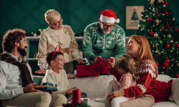 a family laughs together opening christmas presents