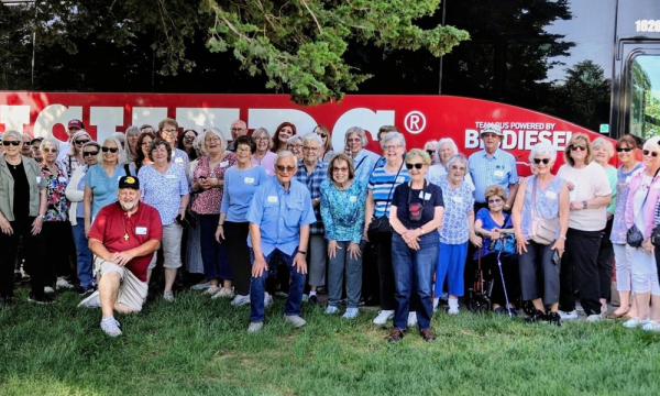 a group of UBT Journey program participants stand in front of a bus