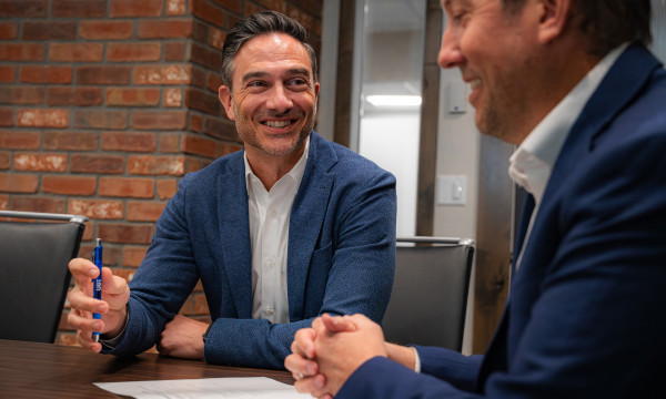 Ryan Sahd sits with a customer discussing 